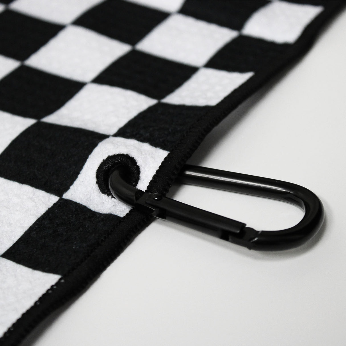 Close up of Utility Towel black carabiner clip with 'Checker' graphic