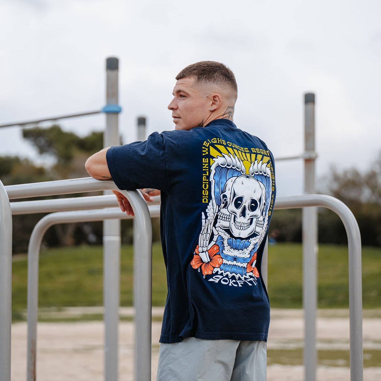 Male model outdoors wearing unisex Street Tee with 'Discipline Weighs Ounces' graphic