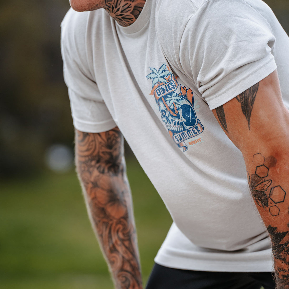 Male model outdoors wearing unisex Active Tee with 'Endless Summer' graphic
