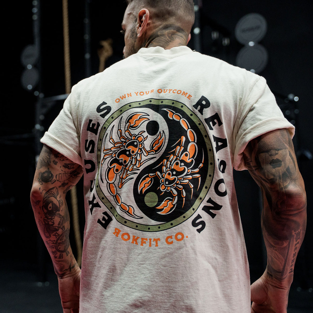 Male model in a gym wearing Street Tee with 'Excuses or Reasons' graphic
