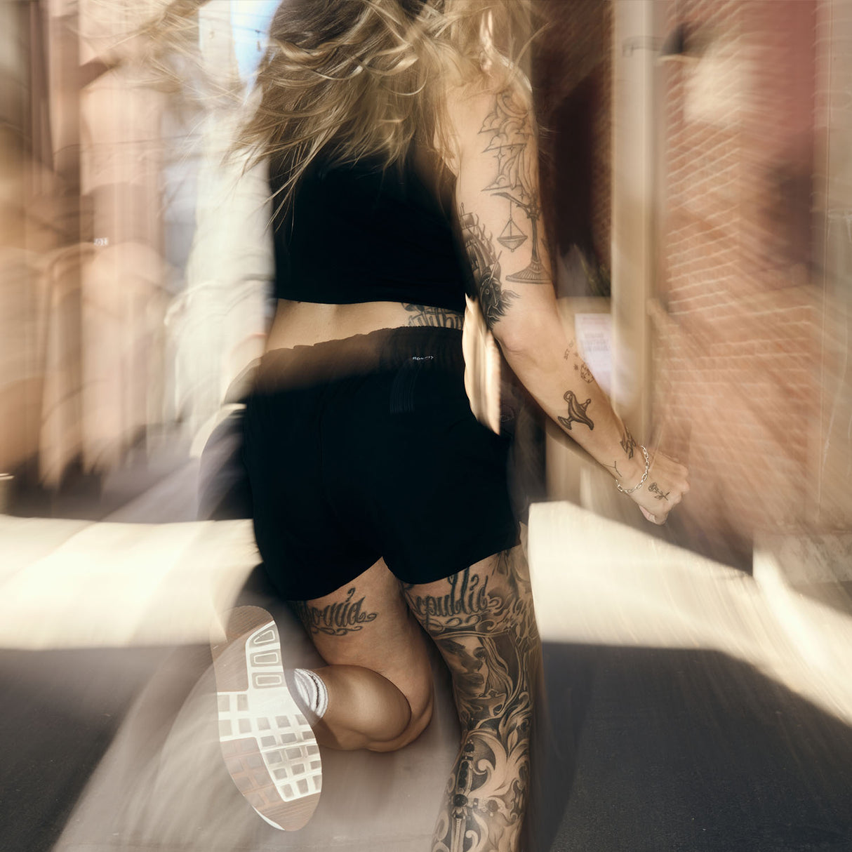 Female model running outdoors wearing women's black Hybrid Shorts