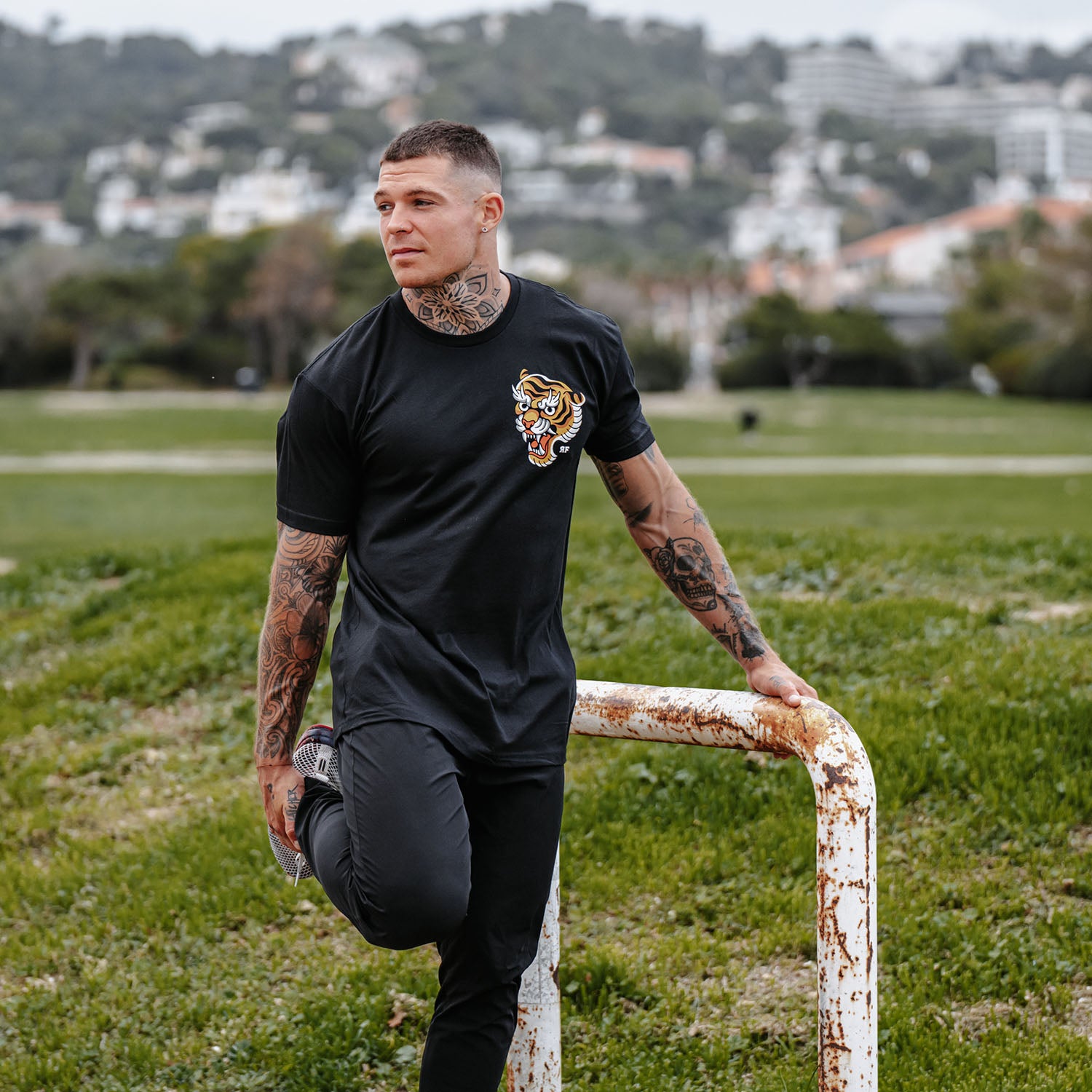 Male model outdoors wearing unisex Active Tee with 'Make Excuses or Make Progress' graphic