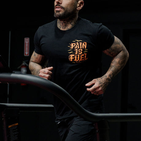 Male model running in a gym wearing Active Tee with 'Pain Is Fuel' graphic